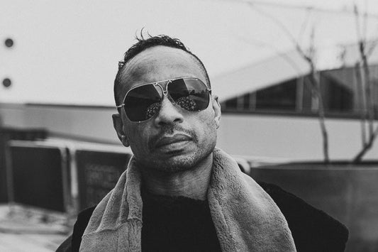 Karl Kani stands in front of a display of vintage hip-hop fashion from the 90s